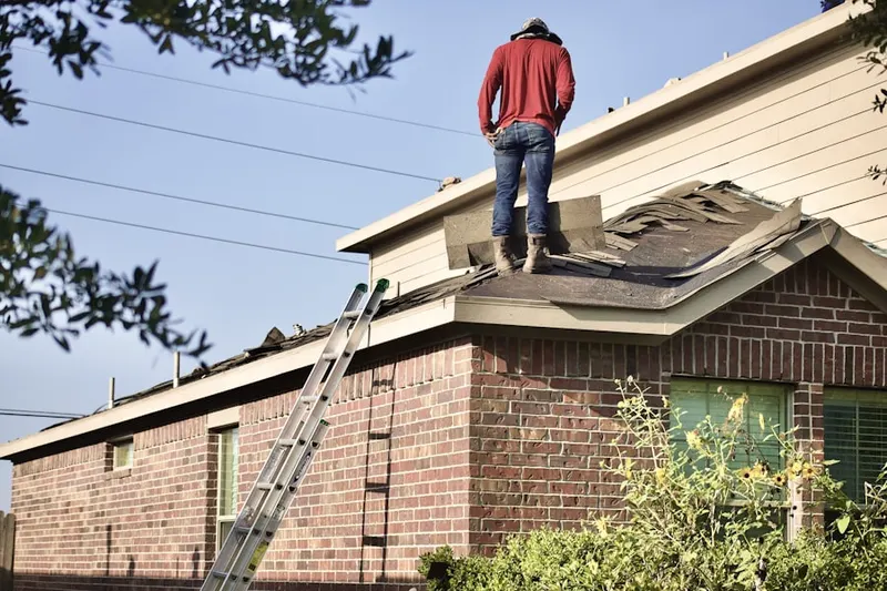 Professional roofer working on a residential roof in Busti